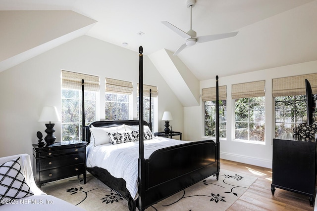 bedroom with lofted ceiling, multiple windows, wood finished floors, and a ceiling fan