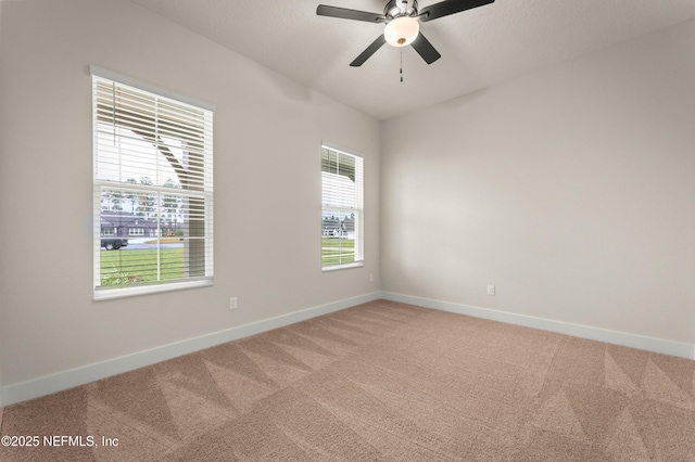 spare room with light carpet, plenty of natural light, baseboards, and a ceiling fan