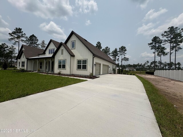 36166 Pitch Ln, Hilliard, FL 32046 - view of property exterior featuring concrete driveway, an attached garage, and board and batten siding