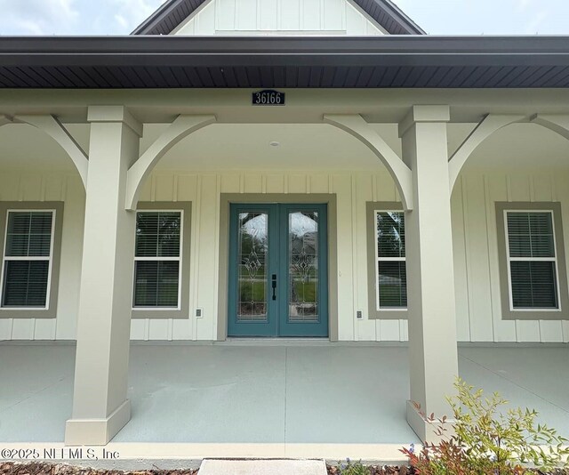36166 Pitch Ln, Hilliard, FL 32046 - view of exterior entry featuring board and batten siding, french doors, and a porch