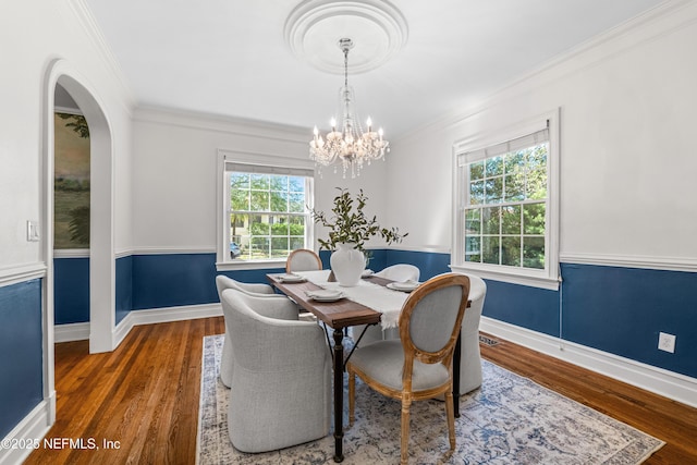 dining space featuring a healthy amount of sunlight, crown molding, and wood finished floors