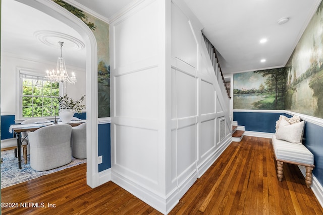 hallway with recessed lighting, wood-type flooring, ornamental molding, a chandelier, and baseboards