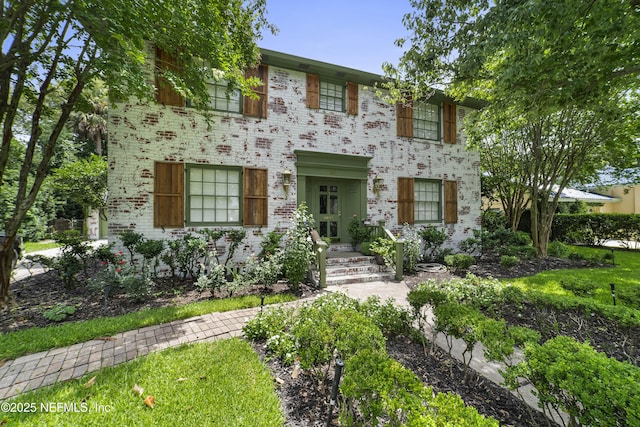 colonial inspired home featuring brick siding