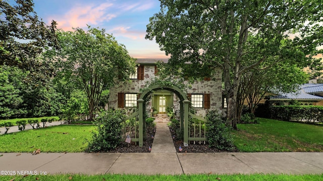 view of front of home with stone siding and a front yard