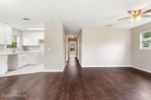 kitchen with light wood-style floors, light countertops, visible vents, and a sink