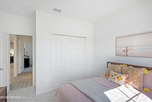 bedroom featuring a closet, visible vents, and light colored carpet