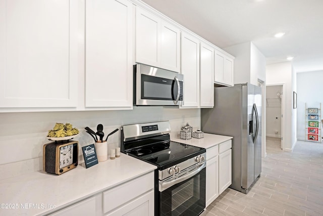 kitchen featuring wood finish floors, recessed lighting, light countertops, appliances with stainless steel finishes, and white cabinetry