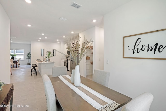 dining area with recessed lighting, visible vents, light wood-style floors, and stairway