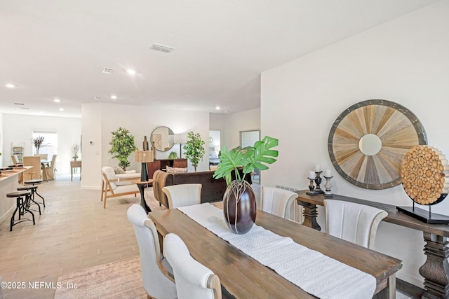 dining space with light wood-type flooring, visible vents, baseboards, and recessed lighting