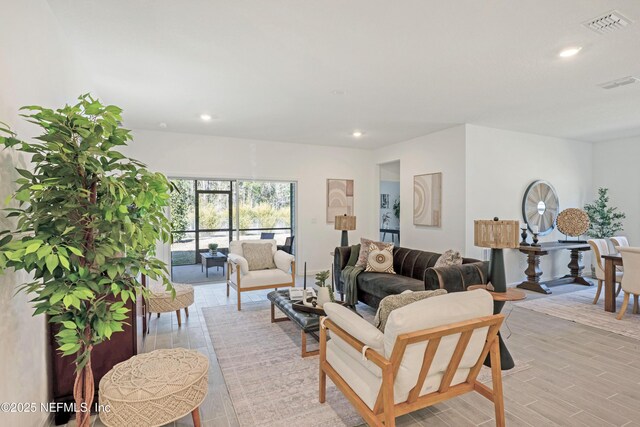 living area featuring light wood-style flooring, recessed lighting, and visible vents