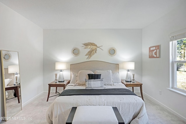 bedroom with multiple windows, light colored carpet, and baseboards