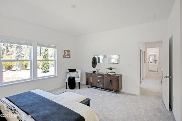 bedroom featuring baseboards, visible vents, and light carpet