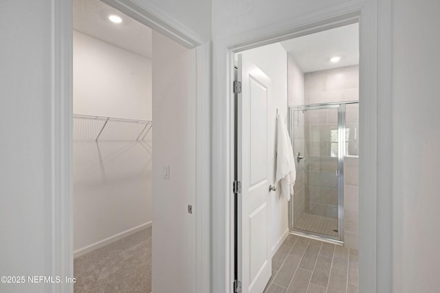 full bath featuring a spacious closet, recessed lighting, and a shower stall