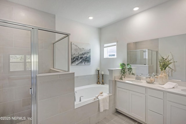 full bath featuring a stall shower, a sink, recessed lighting, double vanity, and a bath