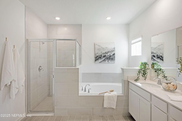 bathroom with vanity, a garden tub, recessed lighting, and a stall shower