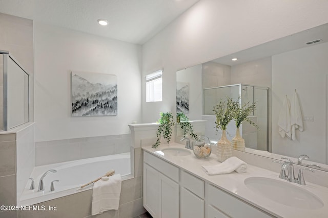 bathroom with visible vents, a stall shower, a garden tub, and a sink