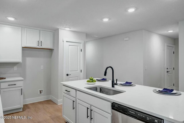 kitchen with dishwasher, light wood-style floors, a sink, and white cabinets