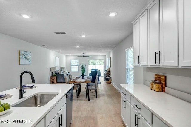 kitchen featuring a sink, visible vents, open floor plan, stainless steel dishwasher, and light wood-type flooring