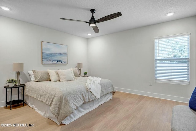 bedroom with a textured ceiling, light wood-style flooring, recessed lighting, a ceiling fan, and baseboards