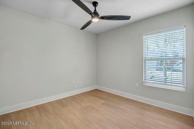 unfurnished room with light wood-type flooring, ceiling fan, baseboards, and a textured ceiling