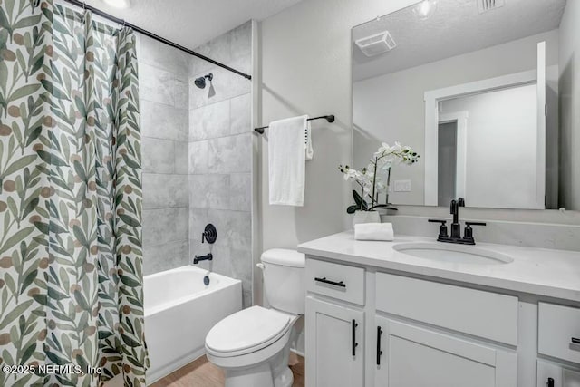 full bath featuring toilet, visible vents, a textured ceiling, and vanity