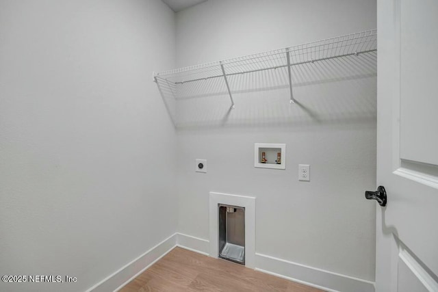 washroom featuring hookup for an electric dryer, laundry area, washer hookup, wood finished floors, and baseboards