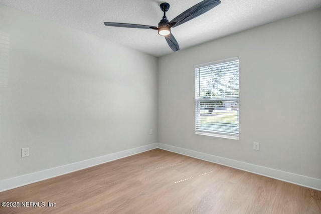 empty room featuring light wood-style floors, ceiling fan, a textured ceiling, and baseboards