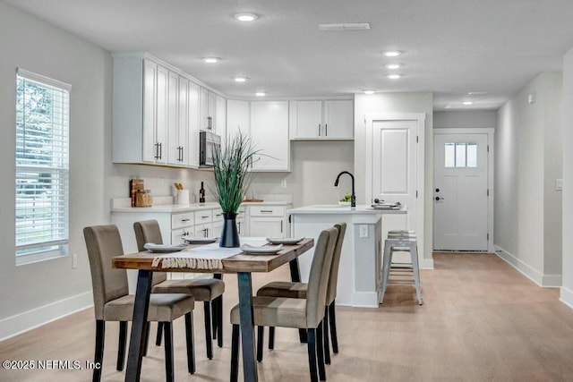 dining space with light wood-style flooring, baseboards, and recessed lighting