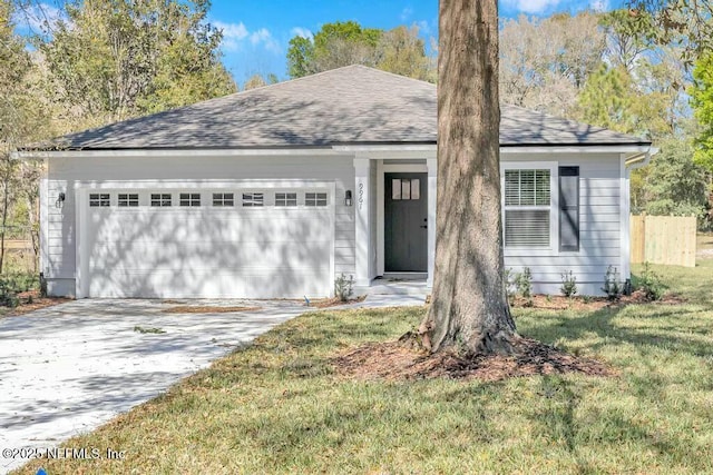 ranch-style home with a garage, a shingled roof, fence, driveway, and a front yard