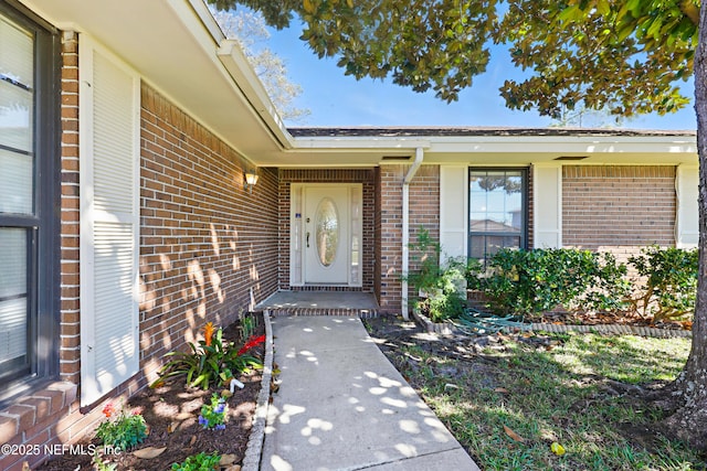 doorway to property featuring brick siding