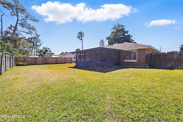 view of yard featuring a fenced backyard and a sunroom