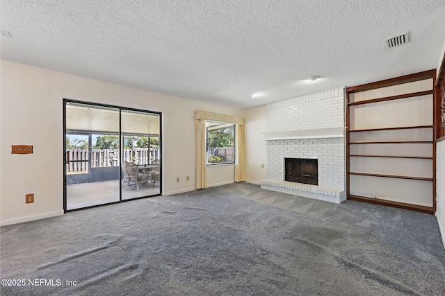 unfurnished living room featuring a brick fireplace, carpet, visible vents, and a textured ceiling