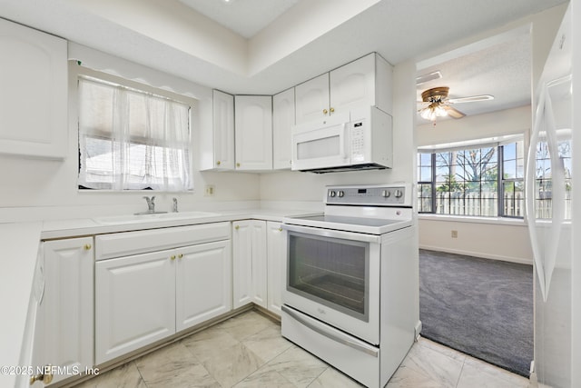 kitchen featuring ceiling fan, white cabinets, marble finish floor, white appliances, and a sink