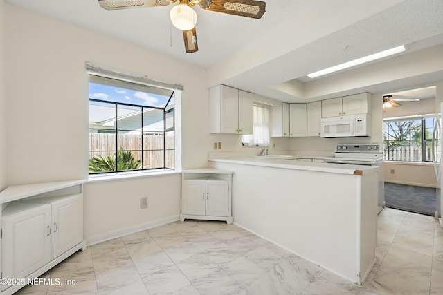 kitchen with marble finish floor, a ceiling fan, a sink, baseboards, and white microwave