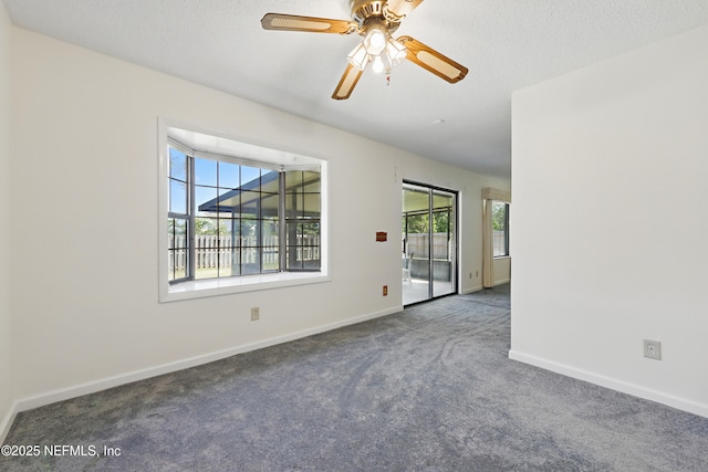 empty room featuring baseboards, a textured ceiling, ceiling fan, and carpet flooring