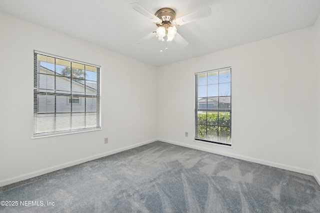 spare room featuring carpet flooring, baseboards, and ceiling fan