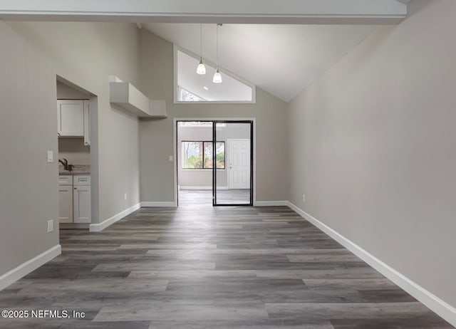 unfurnished room featuring dark wood-type flooring, high vaulted ceiling, and baseboards