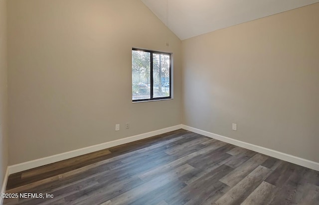 empty room featuring high vaulted ceiling, dark wood-type flooring, and baseboards