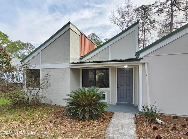 exterior space with metal roof and stucco siding