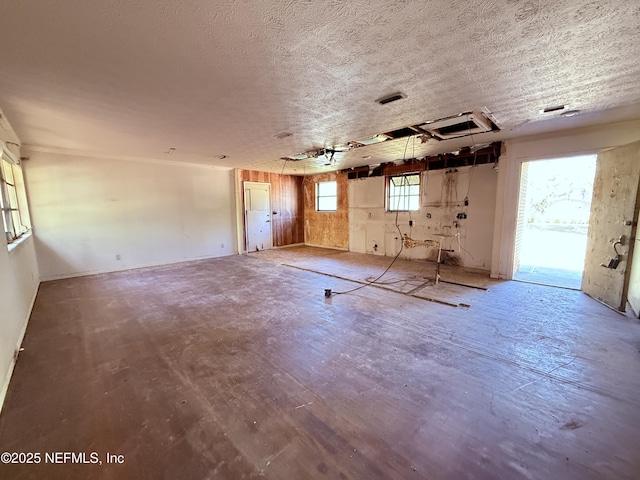 empty room with visible vents, a textured ceiling, and wood finished floors