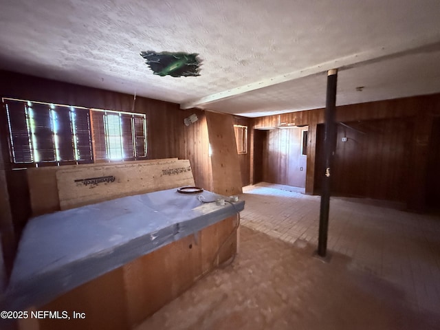 interior space with wood walls and a textured ceiling