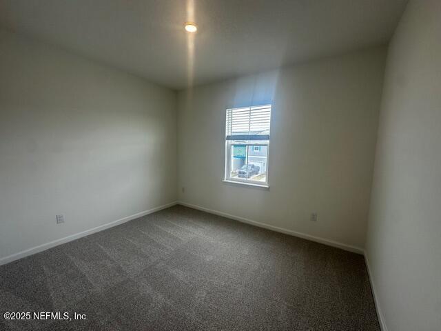 unfurnished room featuring baseboards and carpet floors