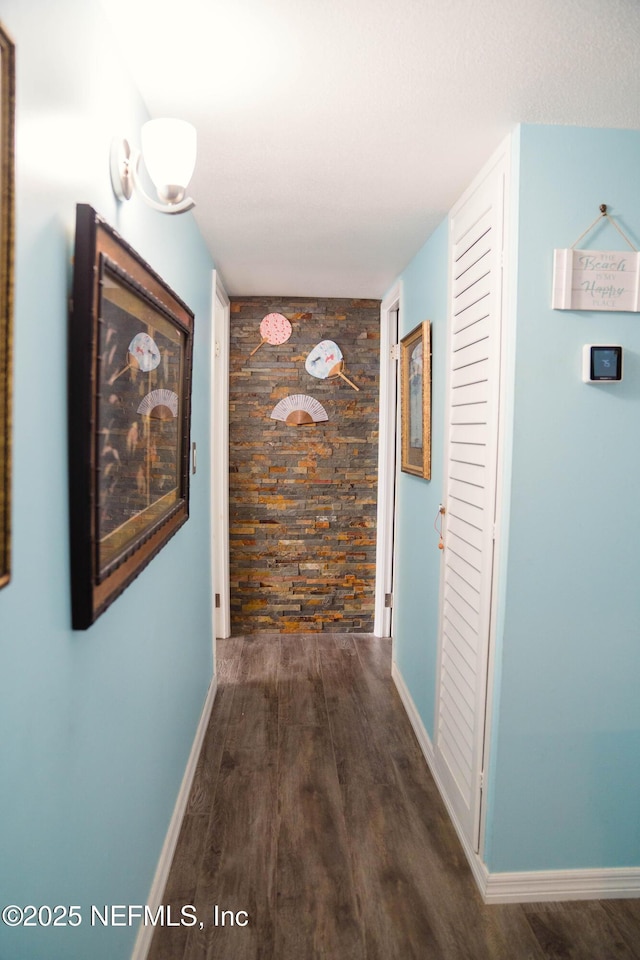 hallway with wood finished floors and baseboards