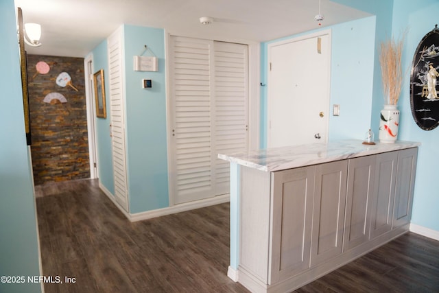 hallway with dark wood finished floors and baseboards