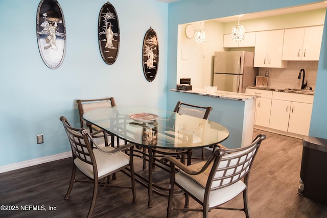 dining area with baseboards and wood finished floors