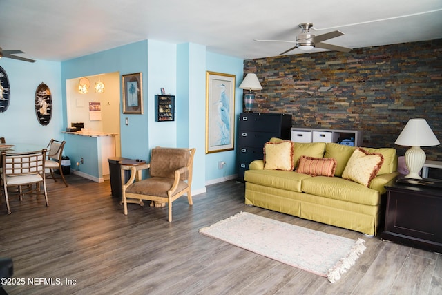 living room featuring ceiling fan, baseboards, and wood finished floors