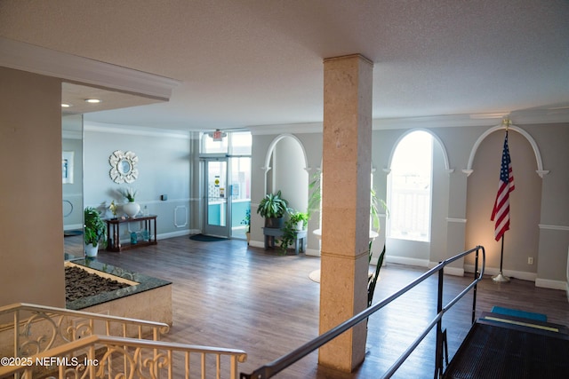 interior space featuring crown molding, baseboards, and wood finished floors