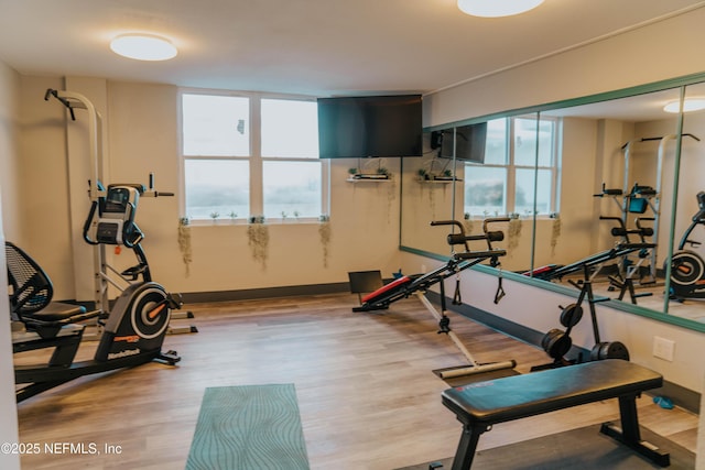 exercise room featuring wood finished floors and baseboards