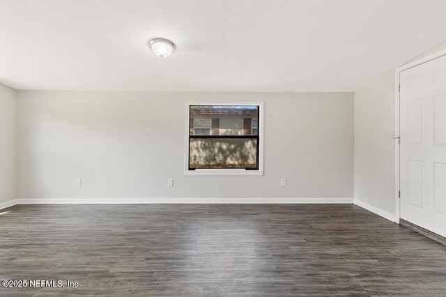 empty room with dark wood-style floors and baseboards