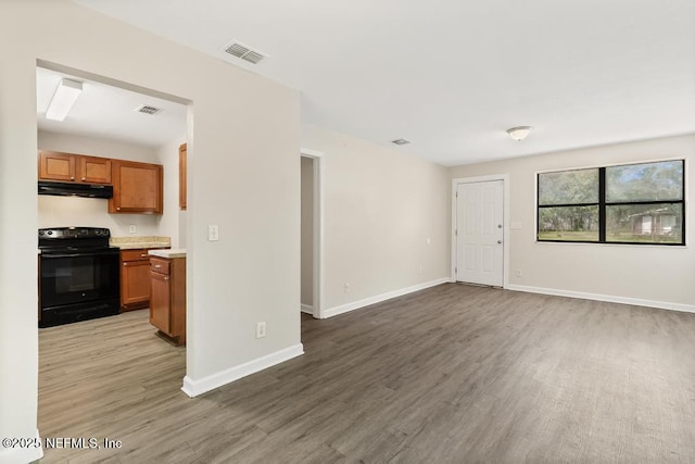 living area with wood finished floors, visible vents, and baseboards